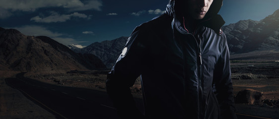 Man wear winter coat on mountain background.