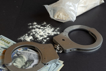 Drugs and handcuffs composition. Selective focus. Crime concept. Illegal money.