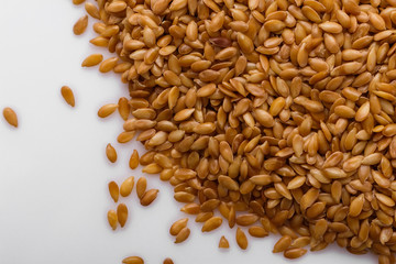 Seeds of golden flax on a white background