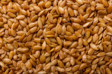 Seeds of golden flax on a white background