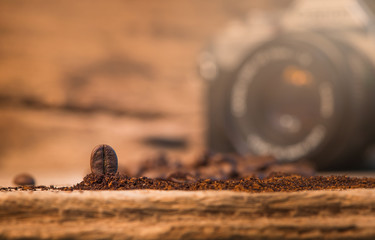 Coffee on wooden table and retro camera in background.