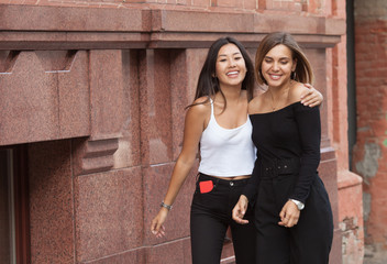 Happy meeting of two friends hugging in the street