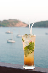 Mojito cocktail drink with evening sunset on beach background