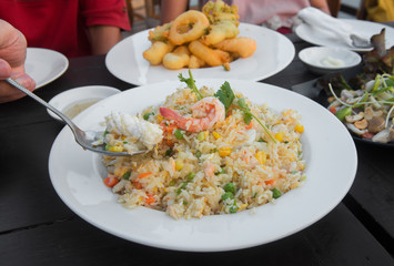 A man eating seafood fried rice in restaurant