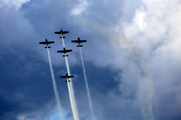 Planes group in acrobatic flight with smoke trace over blue sky
