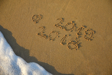 New Year 2019 concept. The inscription on the sand a number message Year 2018 replace 2019