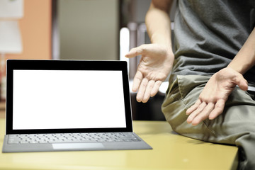 business presentation on screen. mock up blank laptop monitor display for copy space. notebook on table and hands pointing toward in an inviting position.