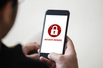Protection security system concept. Man holding smartphone with access denied text on screen.