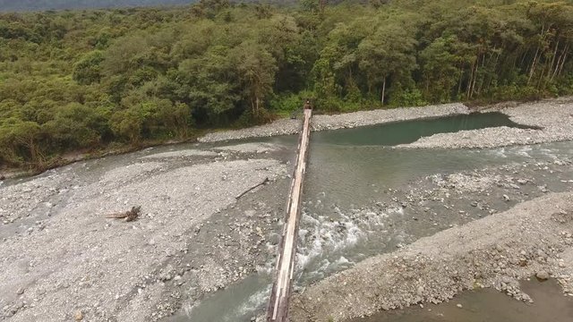 Flying over a rickety suspension footbridge crossing the Rio Cosanga on the Amazonian slopes of the Andes in Ecuador.