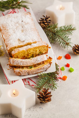 Fototapeta na wymiar Christmas bread with candied fruits and powdered sugar in Christmas decorations.