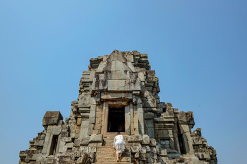 Asian women climb up to Ancient stone castle in Angkor wat Angkor Thom,wonder of the world.