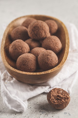 Raw vegan balls from nuts and cocoa in a wooden bowl.