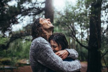 Obraz premium Couple in love embracing in the park under rain