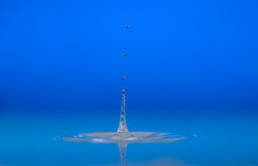 Water drop falling into water making a perfect droplet splash