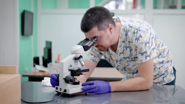Doctor in laboratory looking through microscope