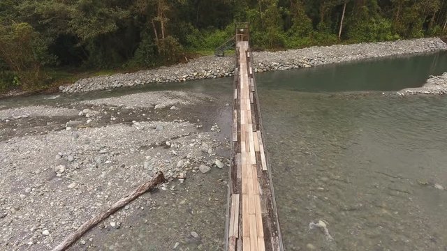 Flying over a rickety suspension footbridge crossing the Rio Cosanga on the Amazonian slopes of the Andes in Ecuador.