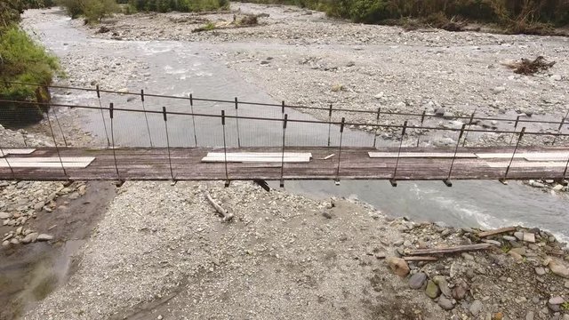 Flying over a rickety suspension footbridge crossing the Rio Cosanga on the Amazonian slopes of the Andes in Ecuador.