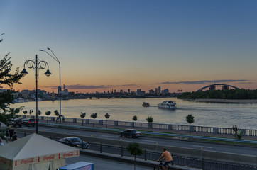 Gentle sunset colors under the river Dnipro and city highway.