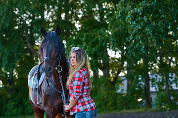 Obraz premium Beautiful girl with long hair on a walk with a horse. Summer cool evening.