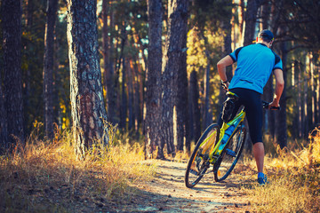 bearded man cyclist rides in the forest on a mountain bike.