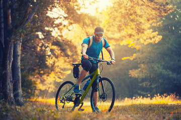 Fototapeta premium bearded man cyclist rides in the forest on a mountain bike.