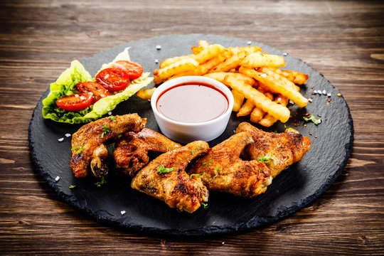 Grilled chicken wings, chips and vegetables