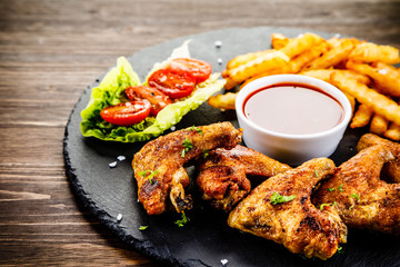 Grilled chicken wings, chips and vegetables