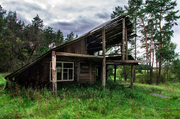 Old gloomy abandoned wooden house in the forest