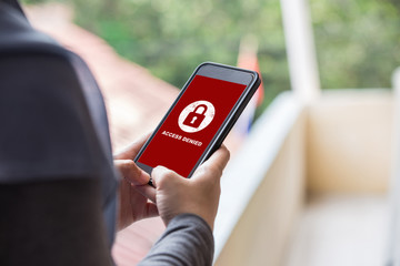 Protection security system concept. Woman holding smartphone with access denied text on screen.