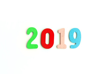 New Year decorative composition with 2019 colorful wooden small numbers. Festive card with empty space for message