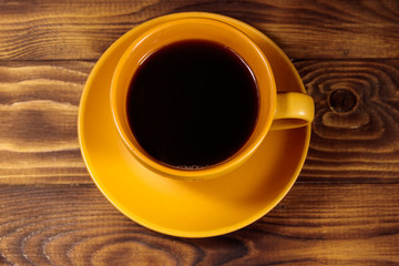 Cup of coffee on the wooden table. Top view
