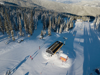 Aerial photo of skiing trails and runs go through the beautiful forest covered mountains