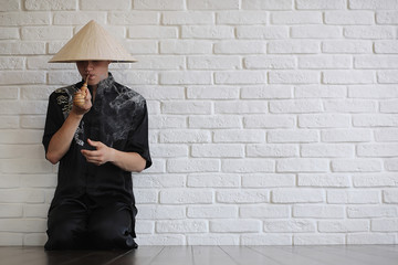 Asian young novice on a white brick wall