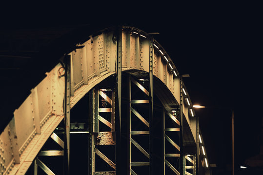 Fototapeta An old steel bridge in various colors, during the night