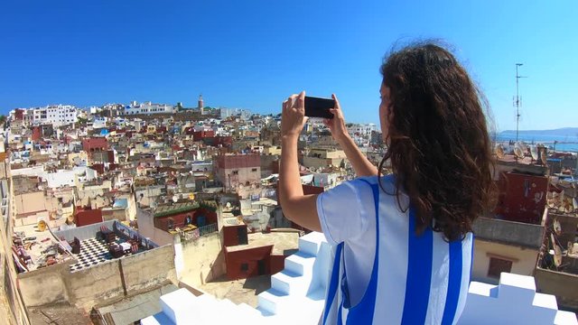 Woman taking pictures of the famous tanger medina from a wonderful terrace