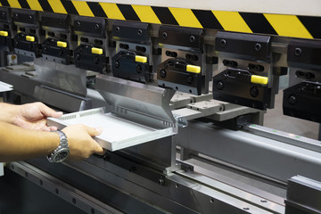 The technician operator use hydraulic bending machine. The sheet metal manufacturing process.
