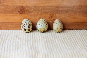 Three quail eggs stand in a row