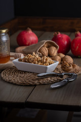 autumn still life with pomegranates, honey and nuts