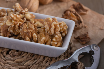 Walnuts cracked on a white ceramic bowl.