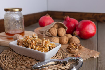 Walnuts, honey and pomegranates with a nutcracker on the table of the kitchen