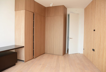 Wood Flooring with modern wooden wall, room door, table and wooden wardrobe.