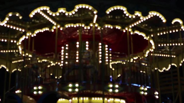 Carousel with horses rotating outdoor in dark night holiday background. Real time full hd video footage.