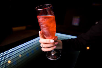 a glass with a red liquid in a beautiful feminine hand