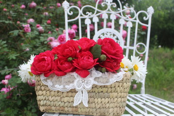 The rose basket on the white chair.