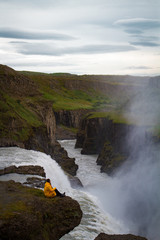 Fototapeta premium Woman stay on waterfall in Iceland, hide waterfall in Iceland, amazing sights and places to explore