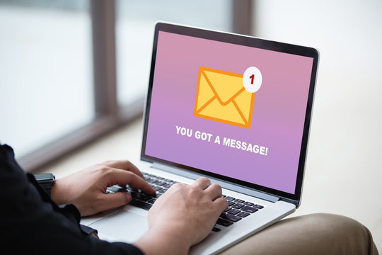 Man working on laptop and got a message from someone at modern office