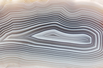 Amazing Banded Agate Crystal cross section as a background. Natural light translucent agate crystal surface, Gray abstract expressive structure slice mineral stone macro closeup
