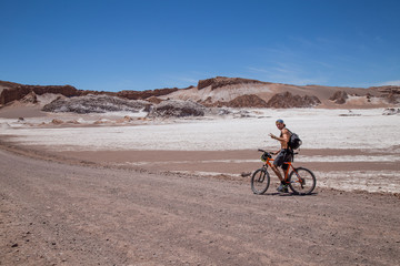Fototapeta na wymiar Homme cycliste dans la Vallée de la lune au Chili Désert d'Atacama paysage lunaire volcans