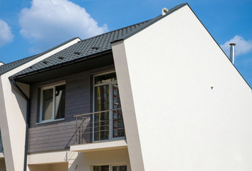 New modern house with plastic windows, metal roof, ventilation, chimney and rain gutter.