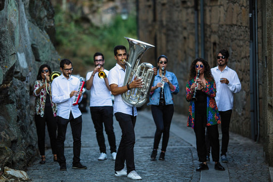 Jazz band a group of musicians with wind instruments playing on the street of the city.